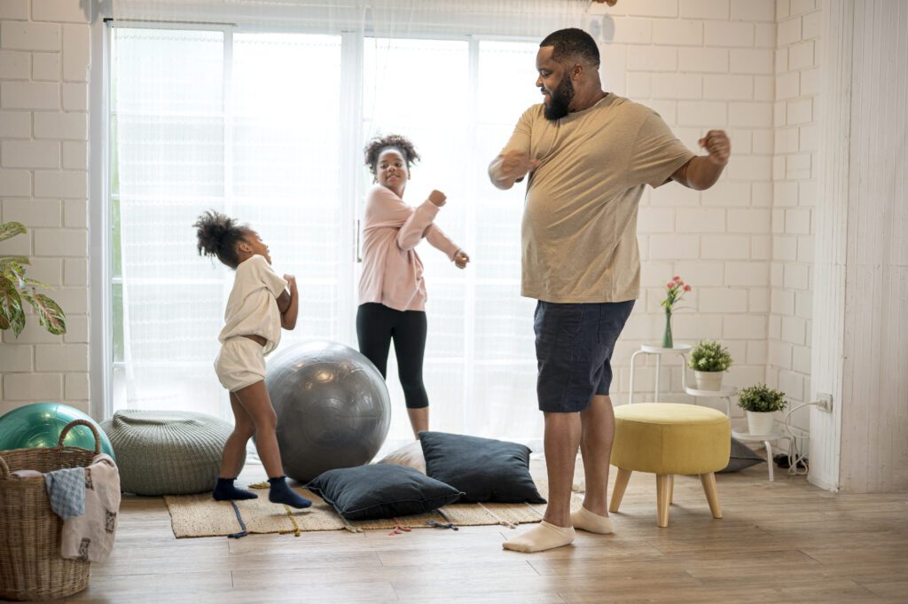 Man doing stretches in a home with two young girls