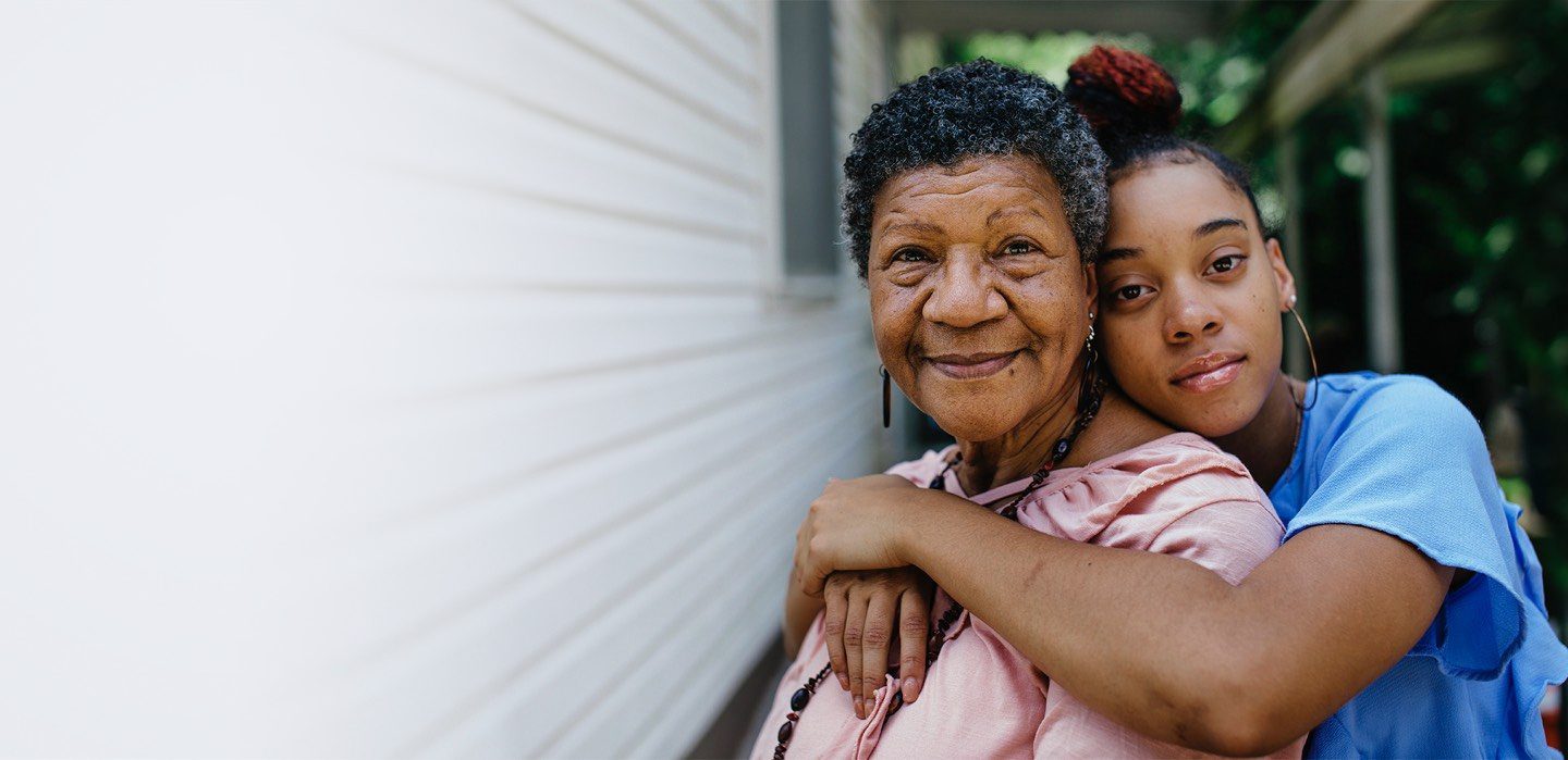 young woman hugging older woman from behind
